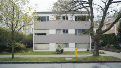 an apartment building with a parking meter in front of it