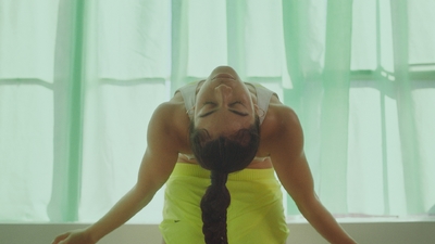 a woman in a yellow skirt is doing a yoga pose