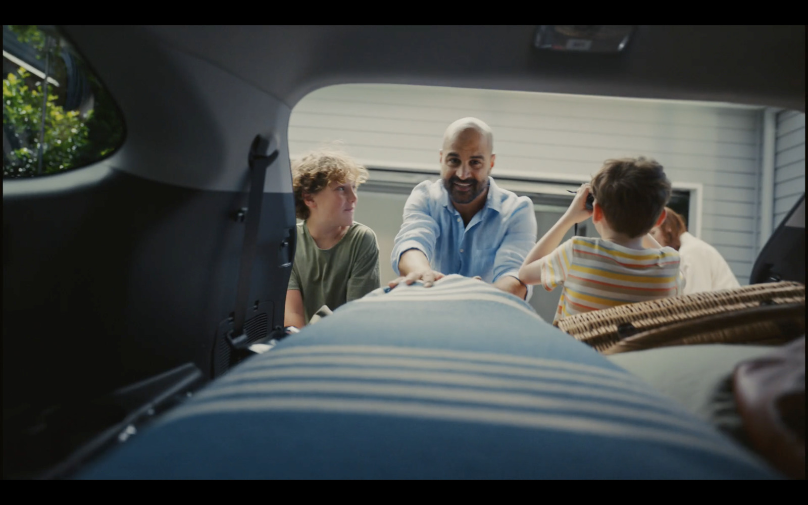 a man and two children sitting in the back of a car