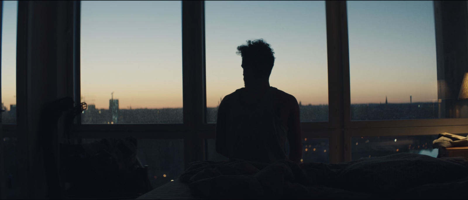 a man standing in front of a window in a bedroom