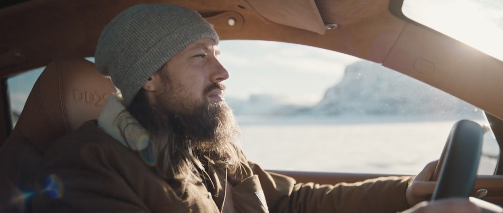 a man with a beard driving a car