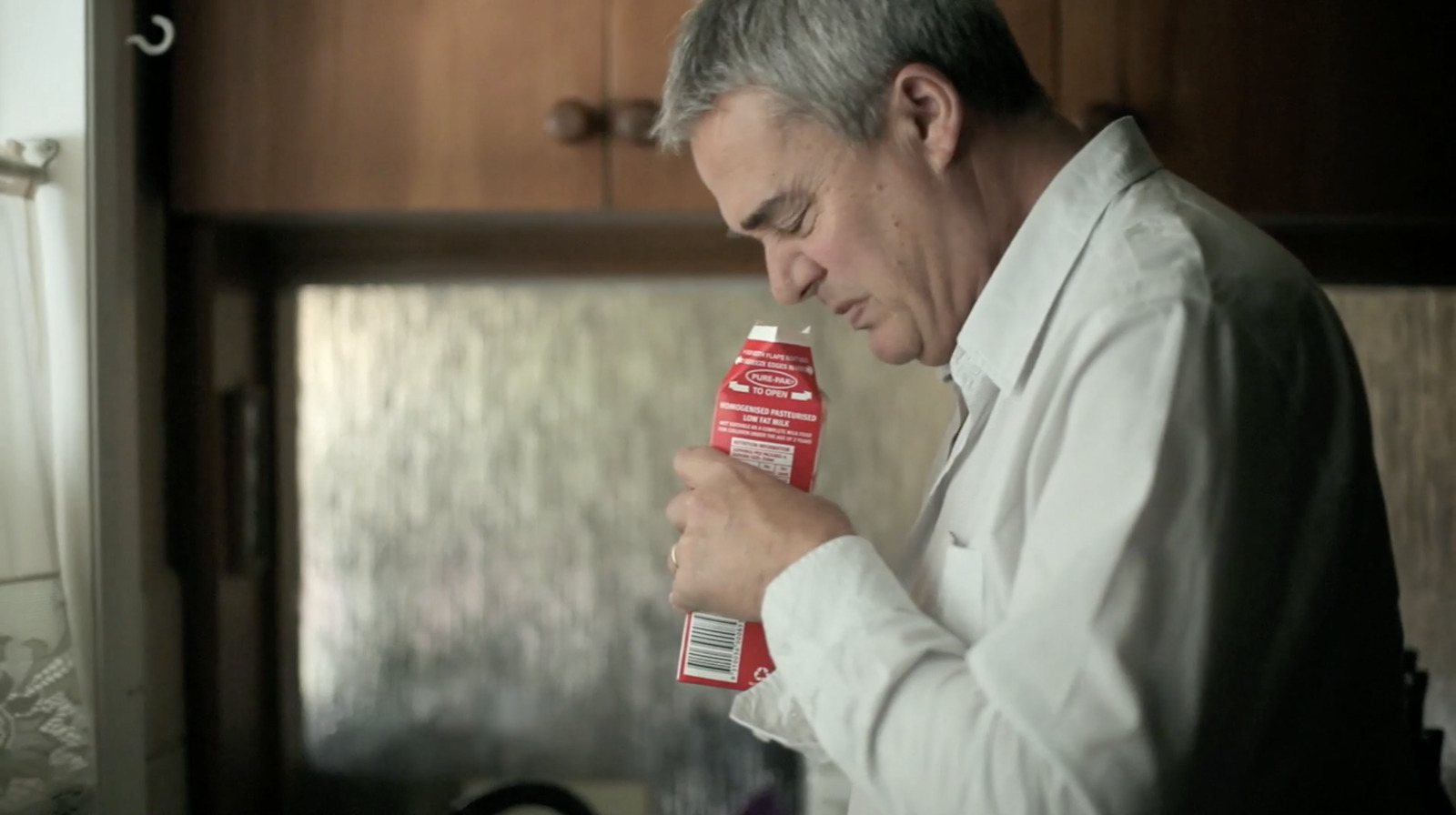 a man holding a carton of milk in his hand