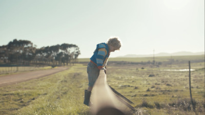 a man standing next to a long pipe in a field