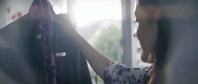 a woman looking at a dress hanging on a rack