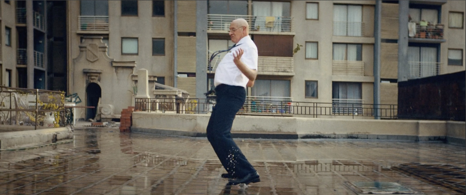 a man riding a skateboard down a wet sidewalk