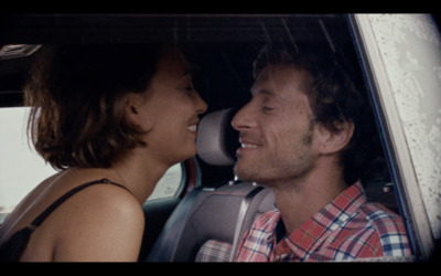 a man and a woman sitting in a car