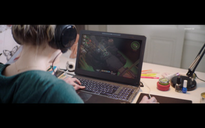 a person sitting at a desk with a laptop and headphones