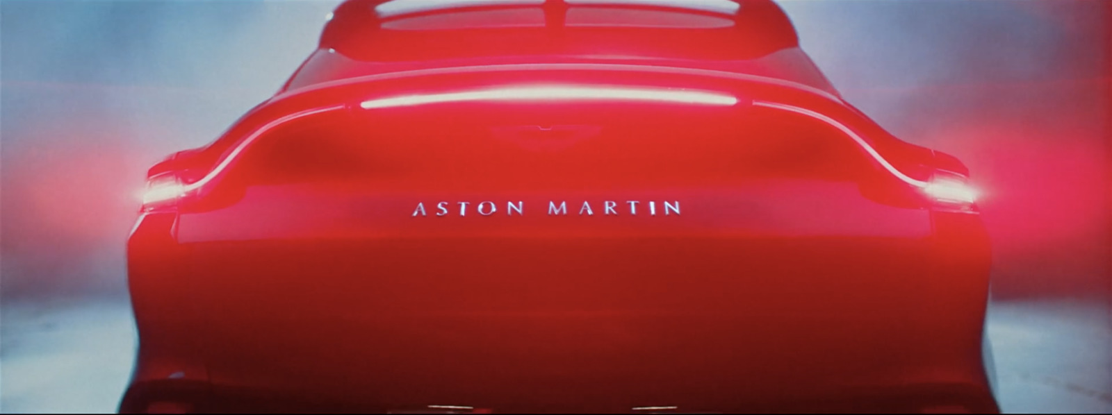 the back end of a red car with the word ashton martin on it