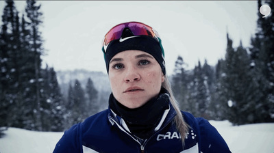 a woman wearing a ski hat and goggles in the snow