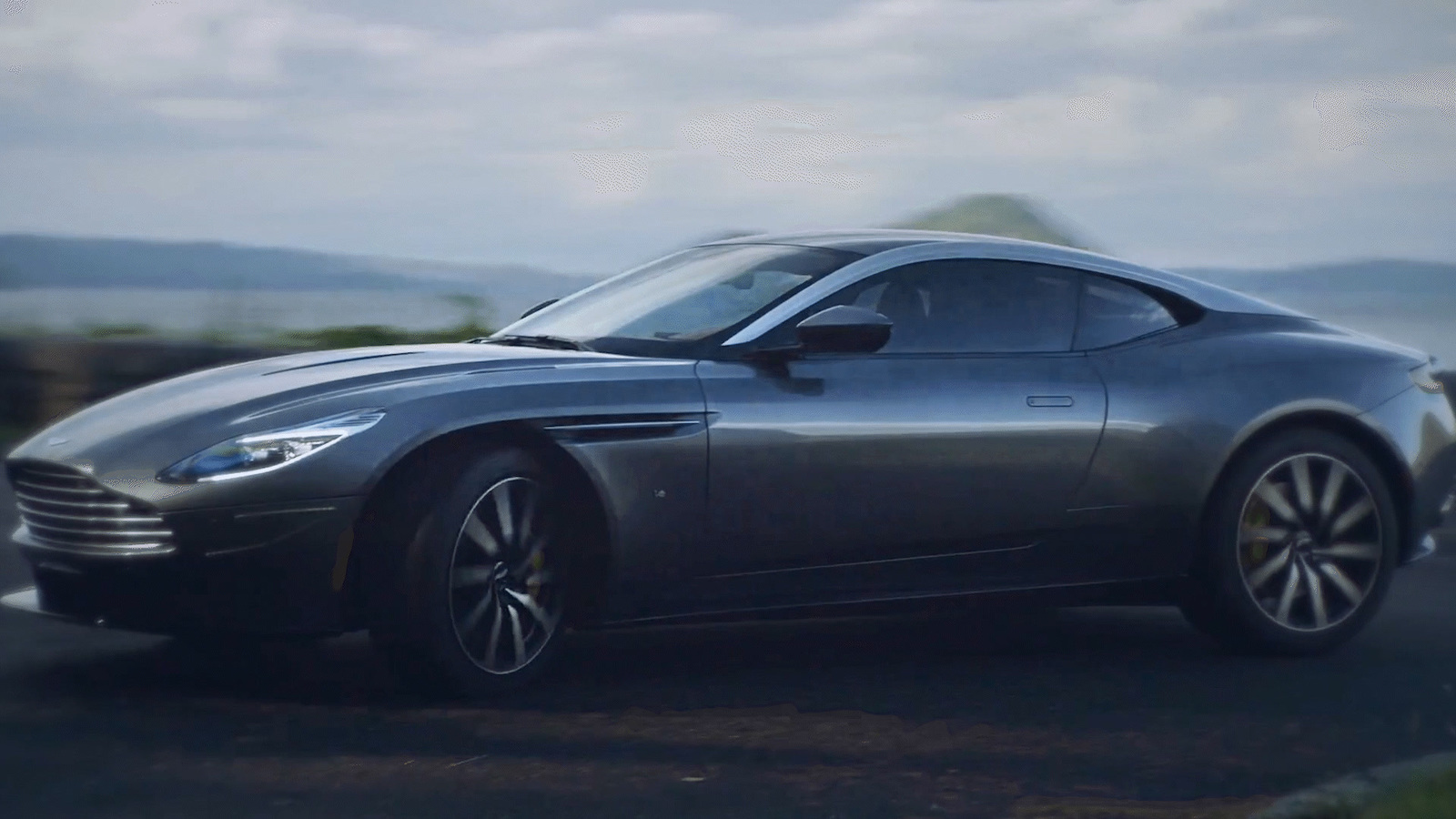 a silver sports car driving down a road