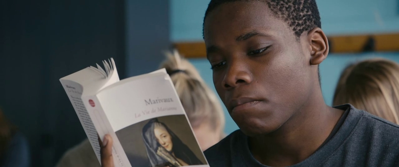 a boy reading a book in a classroom