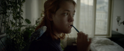 a woman brushing her teeth with a toothbrush