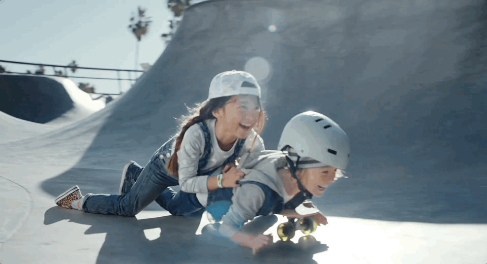 a couple of kids that are on a skateboard