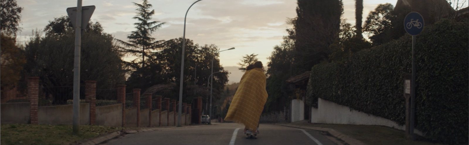 a person walking down a street with a yellow blanket