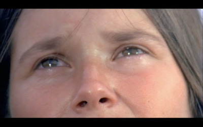 a close up of a woman's face with blue eyes