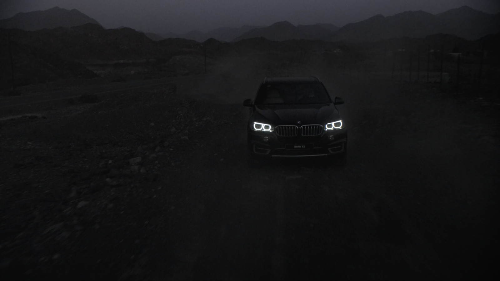 a car driving down a dirt road at night