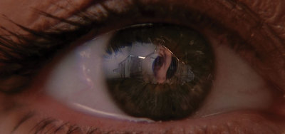 a close up of a person's eye with the reflection of a house in