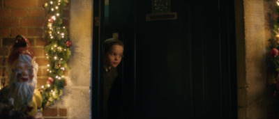 a young boy looking out of a doorway