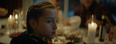 a young girl standing in front of a table with candles