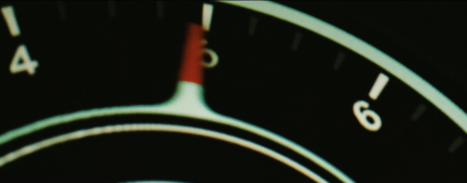 a close up of a speedometer with a red needle