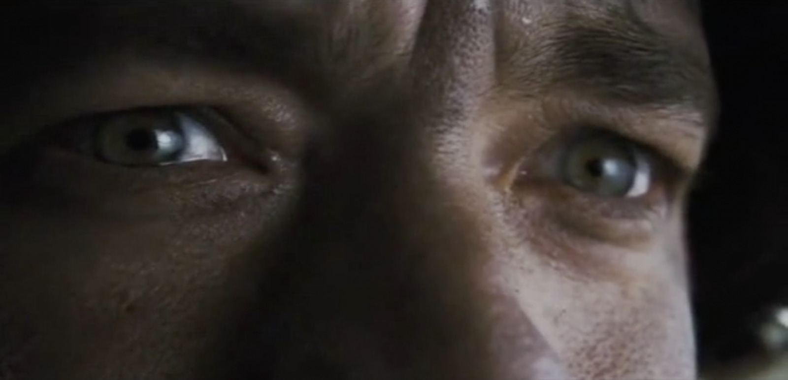 a close up of a man's face with blue eyes