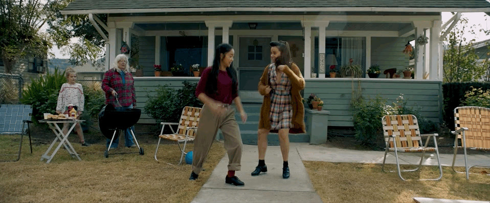 a couple of women standing in front of a house