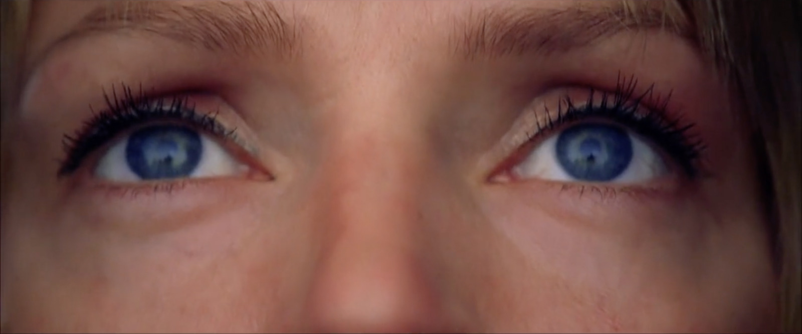 a close up of a woman's blue eyes