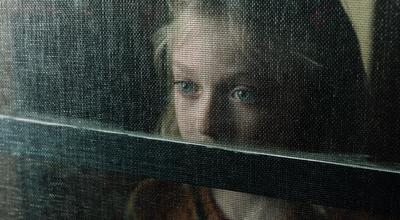 a woman looking through a window at something