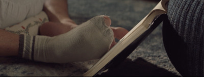 a person with a cast on their foot reading a book