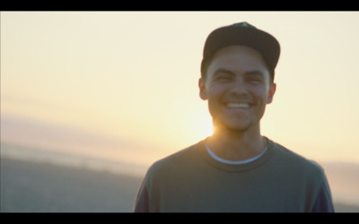 a man in a baseball cap smiles at the camera