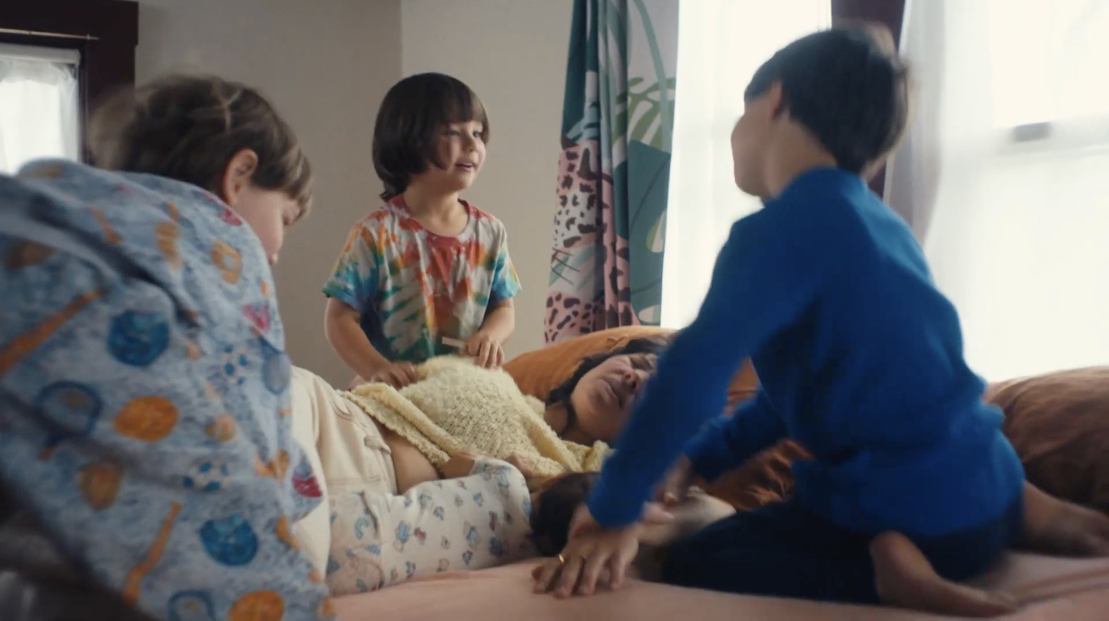 a group of people sitting around a bed