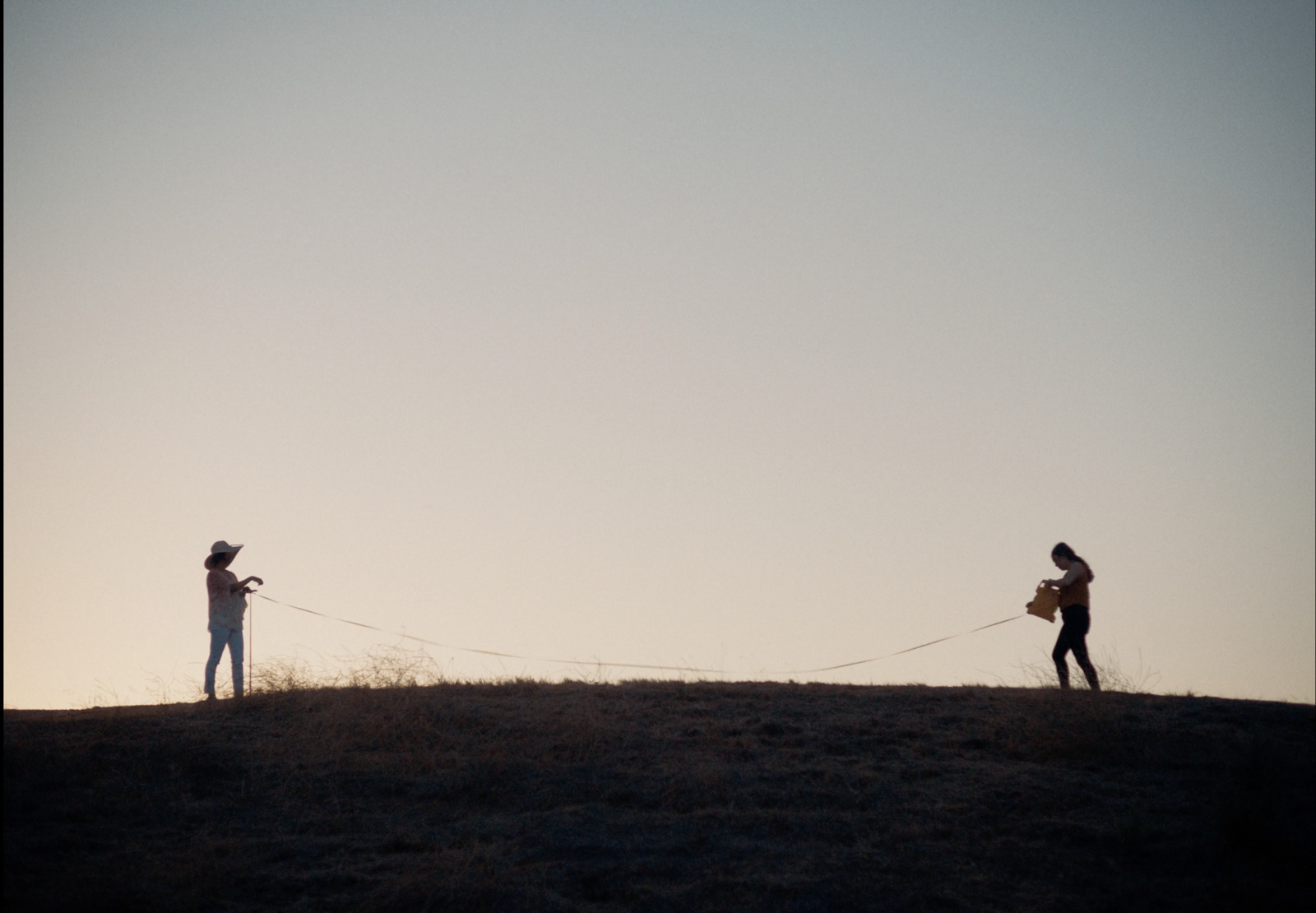 a couple of people standing on top of a hill