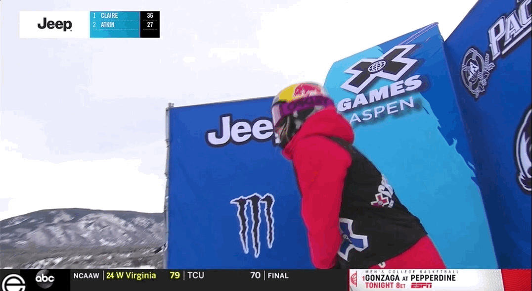 a person on a snowboard in front of a sign