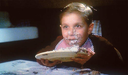 a young boy eating a plate of food