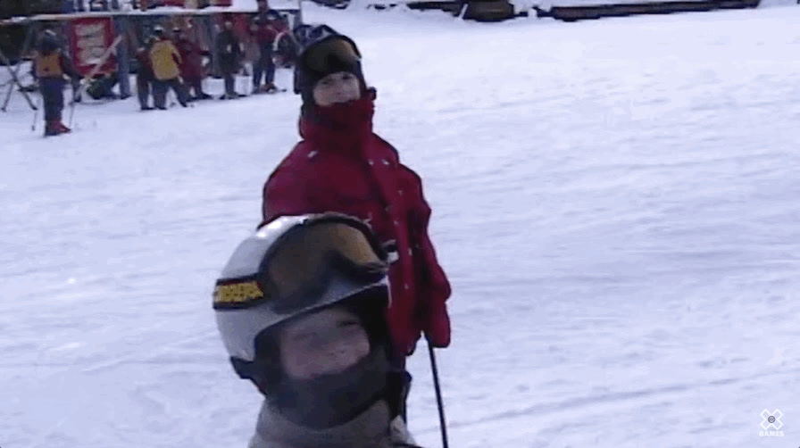 a young person riding skis down a snow covered slope