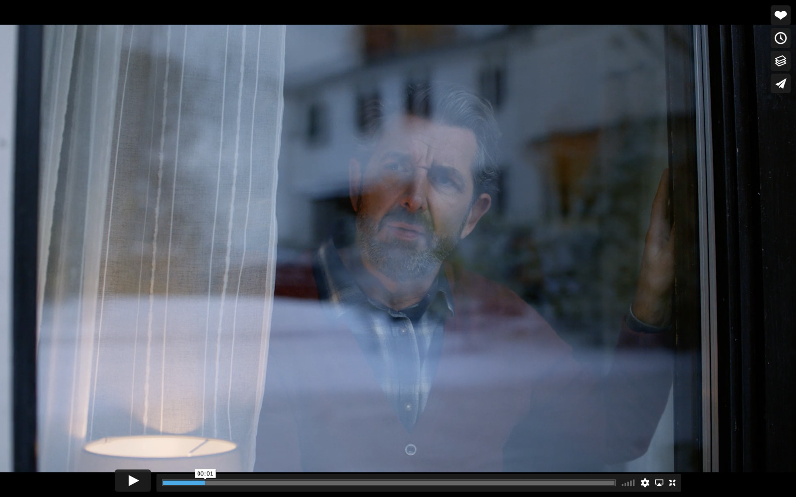 a man looking out of a window at a building