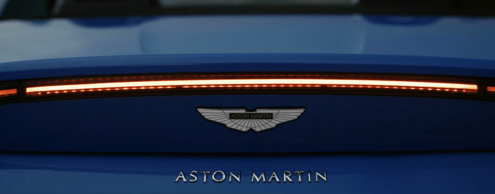 a close up of the tail light of a blue sports car