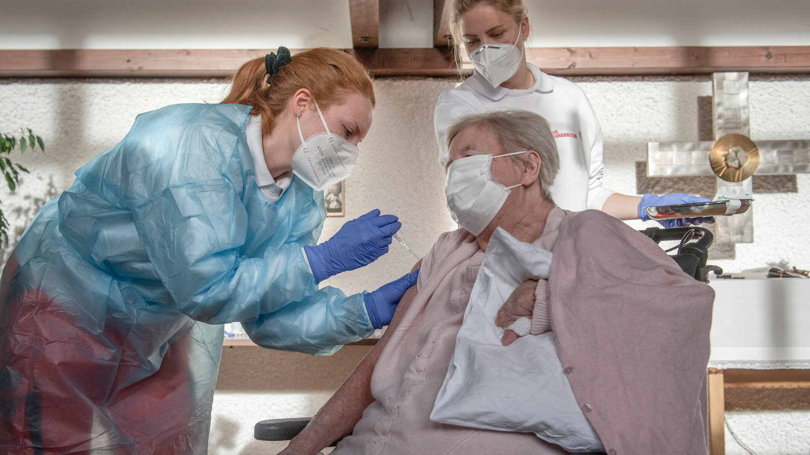 a woman in a hospital gown is being assisted by a nurse