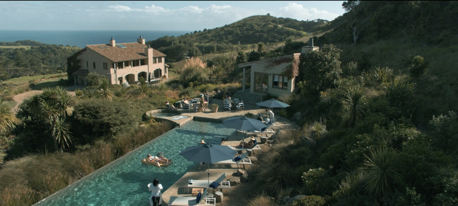 an aerial view of a house with a pool in the foreground