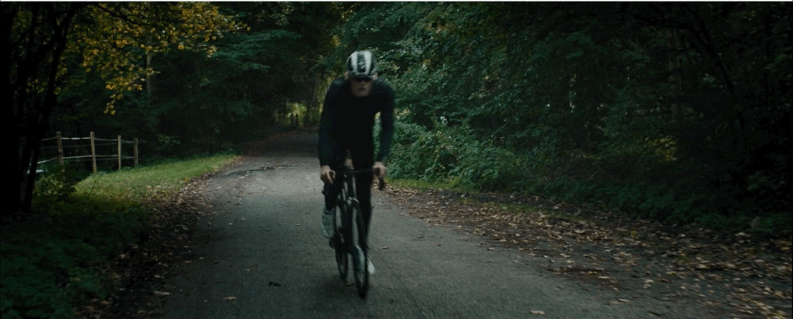 a man riding a bike down a dirt road