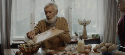 an old man holding a wooden board next to a bowl of mushrooms