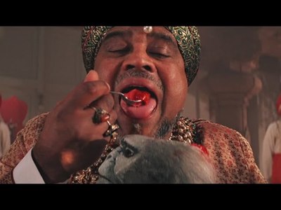 a man in a turban eating food from a spoon