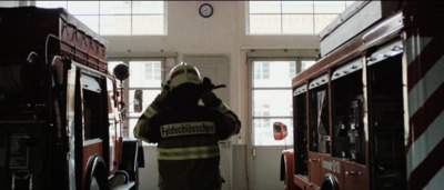 a firefighter is carrying his dog in a fire station