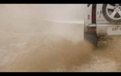 a white truck driving down a dirt road