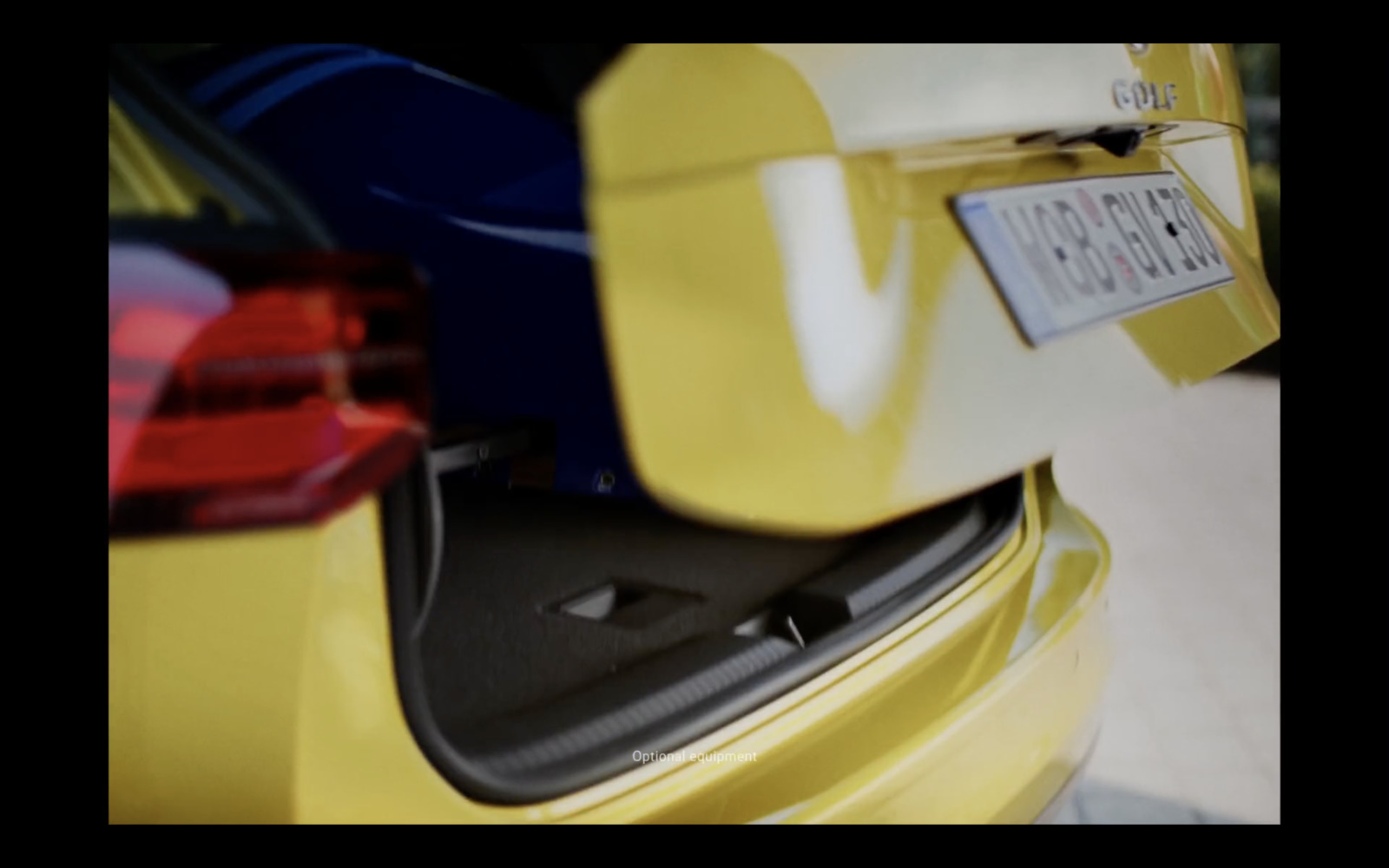 the trunk of a yellow car with a license plate