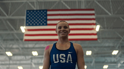 a woman standing in front of an american flag