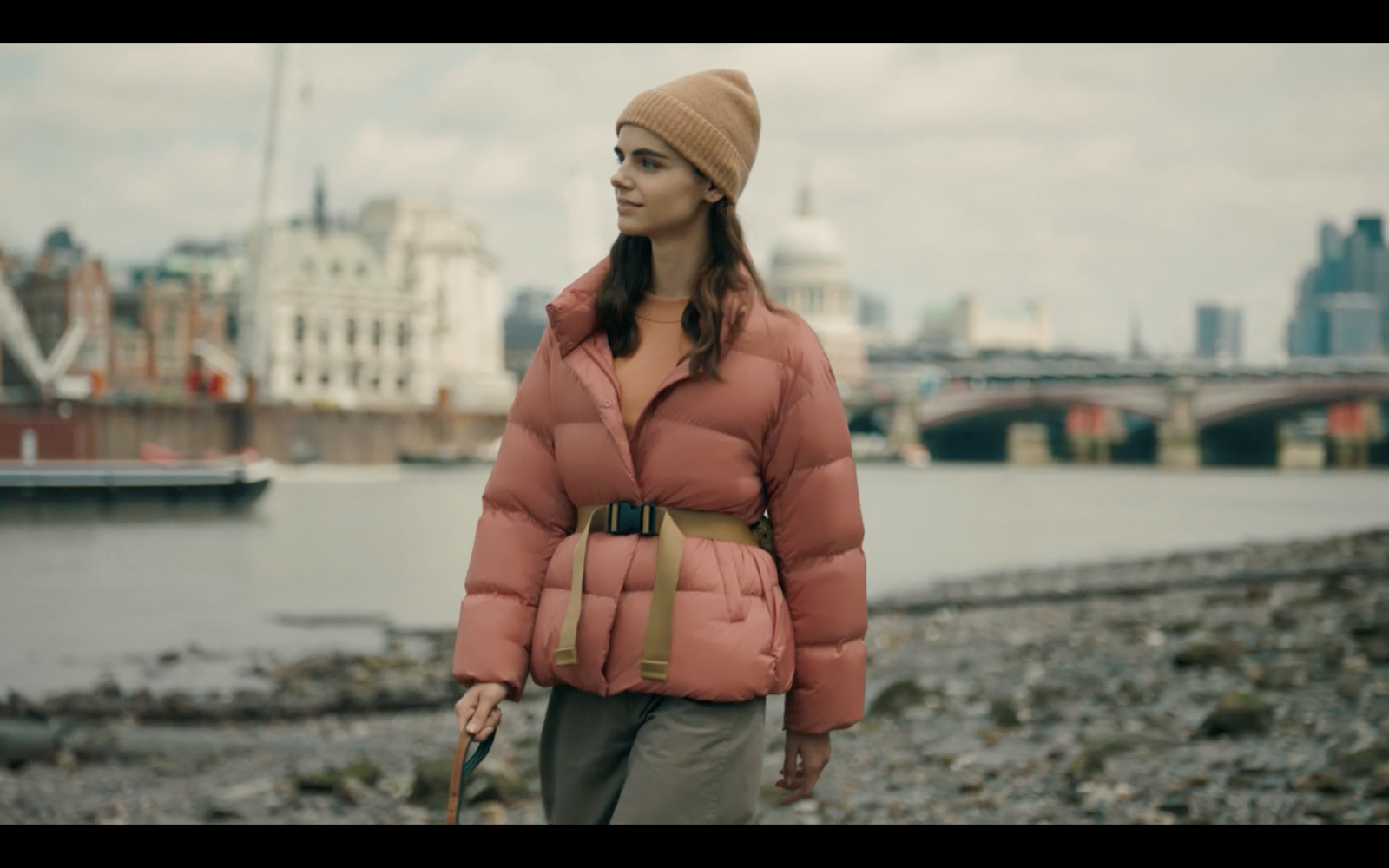 a woman in a pink jacket and a brown hat