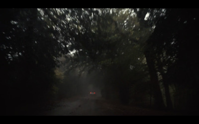 a car driving down a road in the dark