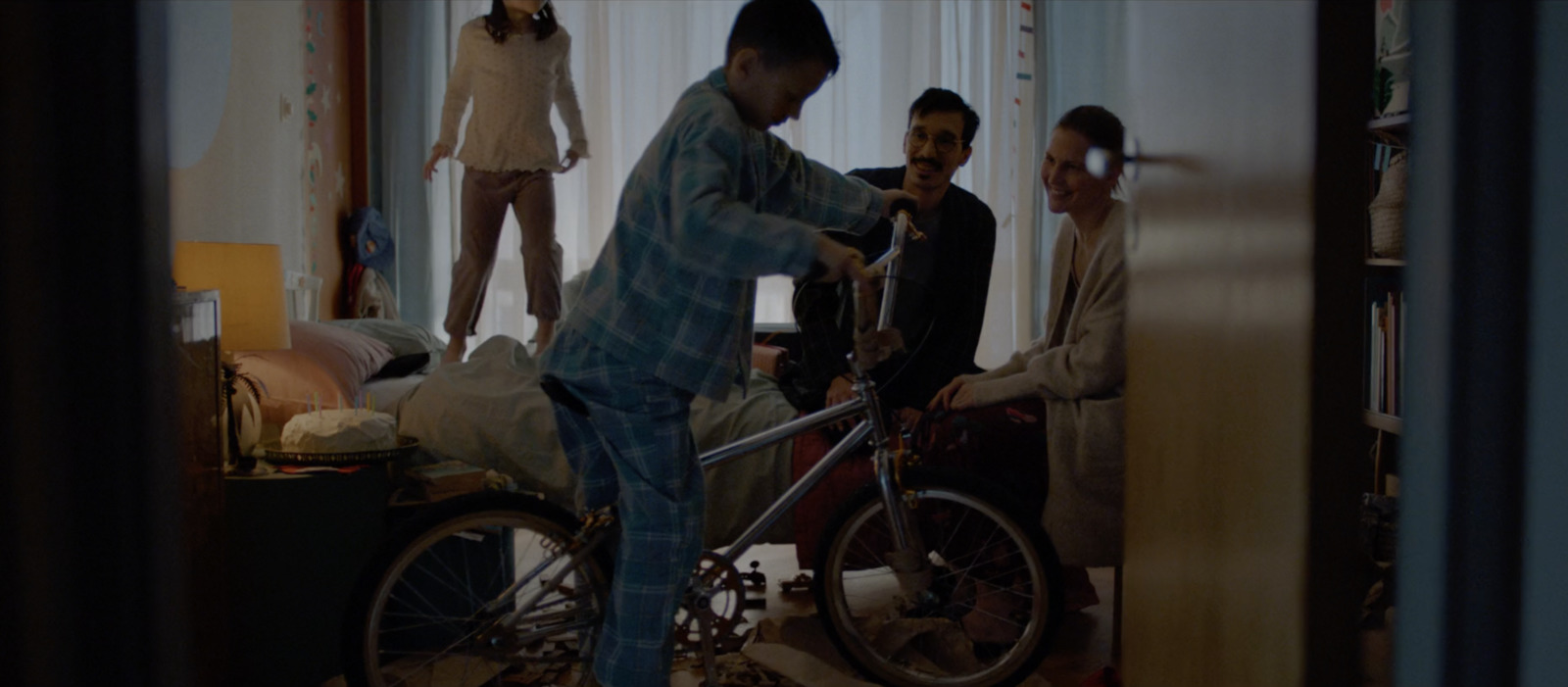 a group of people standing around a room with a bike