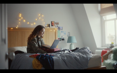 a woman sitting on a bed using a laptop computer